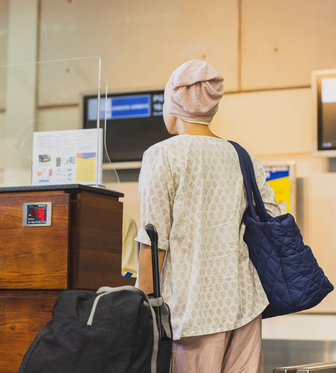 Dlaczego nie warto oznaczać walizki kolorową wstążką Foto: Kobieta z bagażami na lotnisku