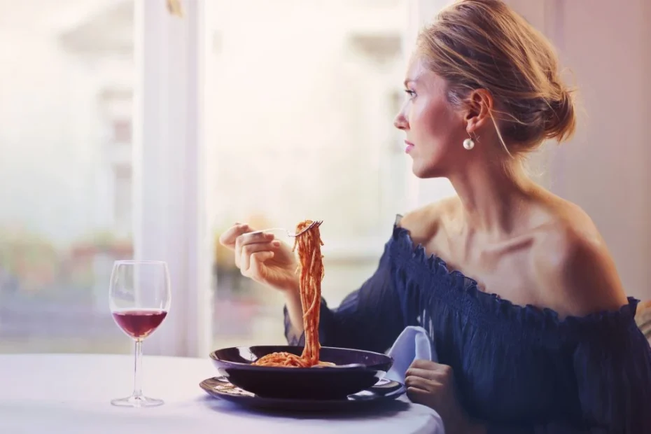 Jedzenie które powoduje smutek Foto: kobieta przy stole spożywająca posiłek