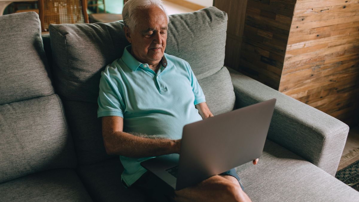 emeryci w UK dostaną dodatkowy rok zwolnienia z podatku Foto: emeryt z laptopem na kolanach