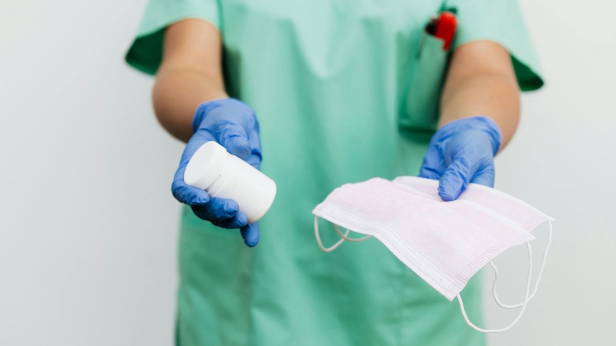 Nowa mutacja wirusa grypy w UK Foto: ręce w rękawiczkach podające maseczkę i leki