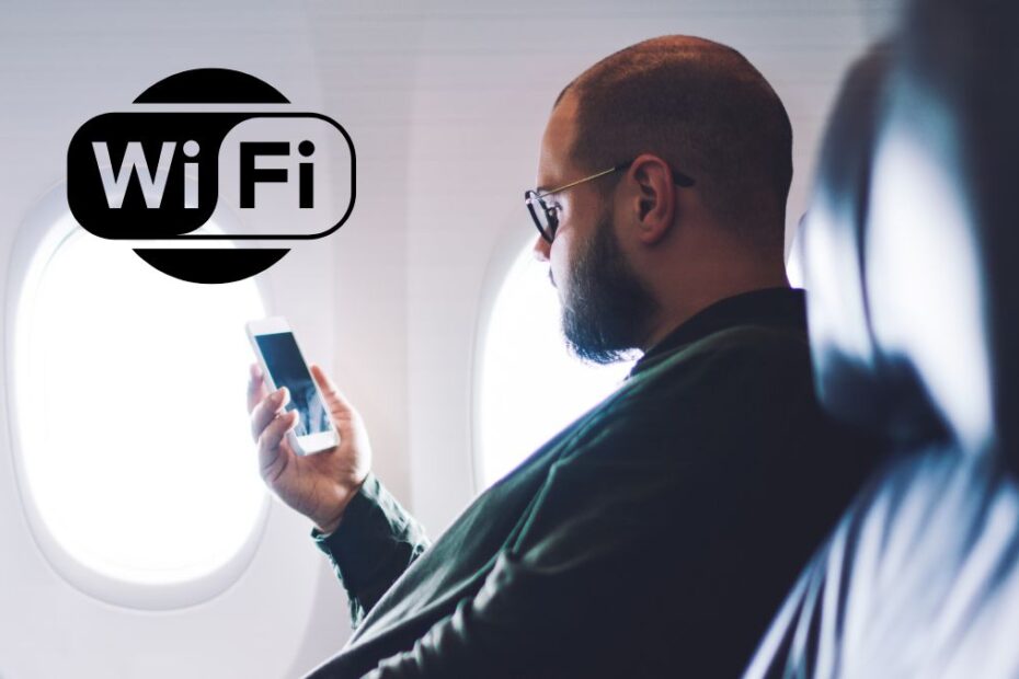 Wizz Air wprowadza WiFi na pokładzie Foto: mężczyzna patrzący na ekran telefonu w samolocie