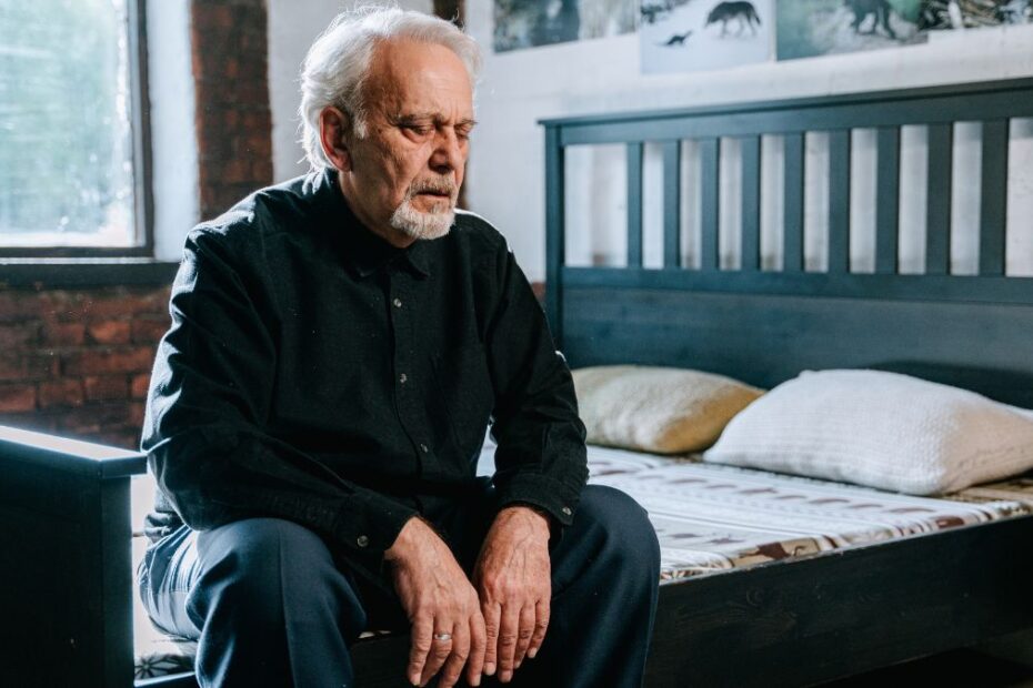 przewlekły niedobór snu może powodować Alzheimera Foto: starszy mężczyzna siedzący na łóżku