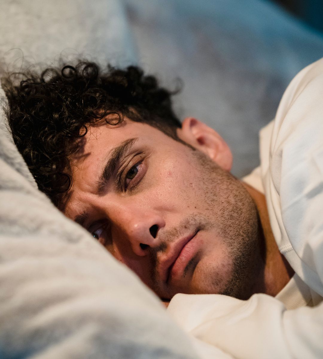 młodzi dorośli czują bardziej samotni od seniorów Foto: mężczyzna leżący w łóżku