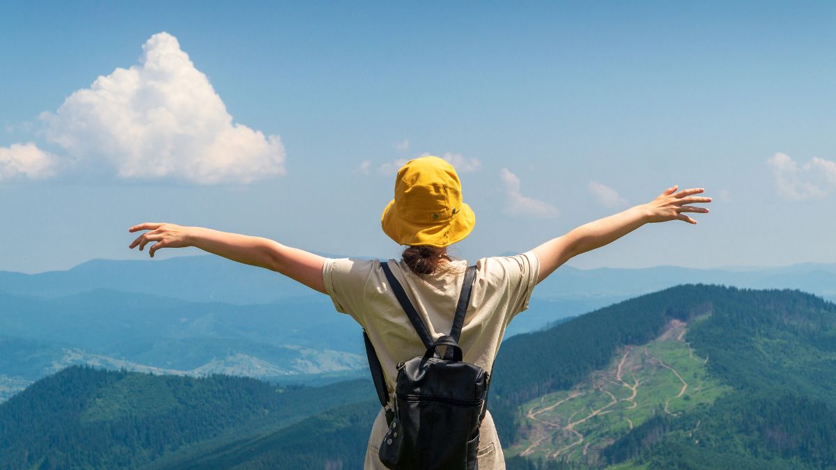 Horoskop podróżniczy 2026 Foto: kobieta na szczycie góry