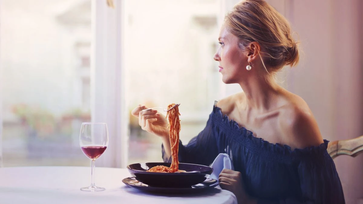 Jedzenie które powoduje smutek Foto: kobieta przy stole spożywająca posiłek