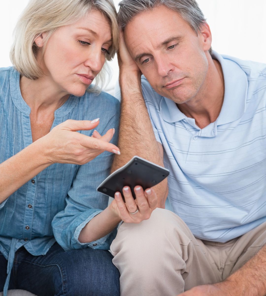 Ostrzeżenie dotyczące emerytury państwowej w UK Foto: kobieta i mężczyzna dokonujący obliczeń na kalkulatorze