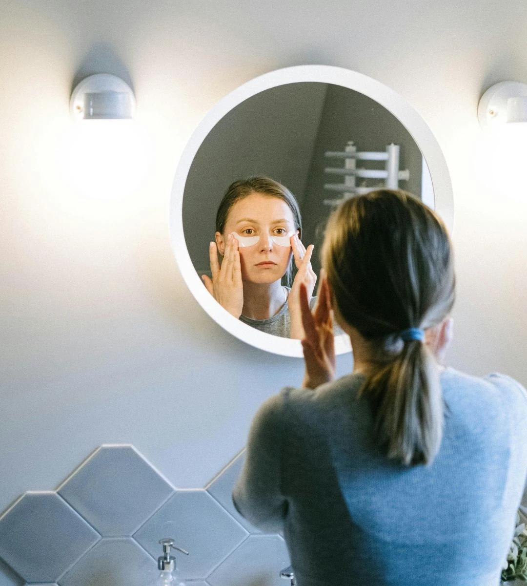 Dieta i zdrowe nawyki po 40. roku Foto: Kobieta nakładająca krem przed lustrem