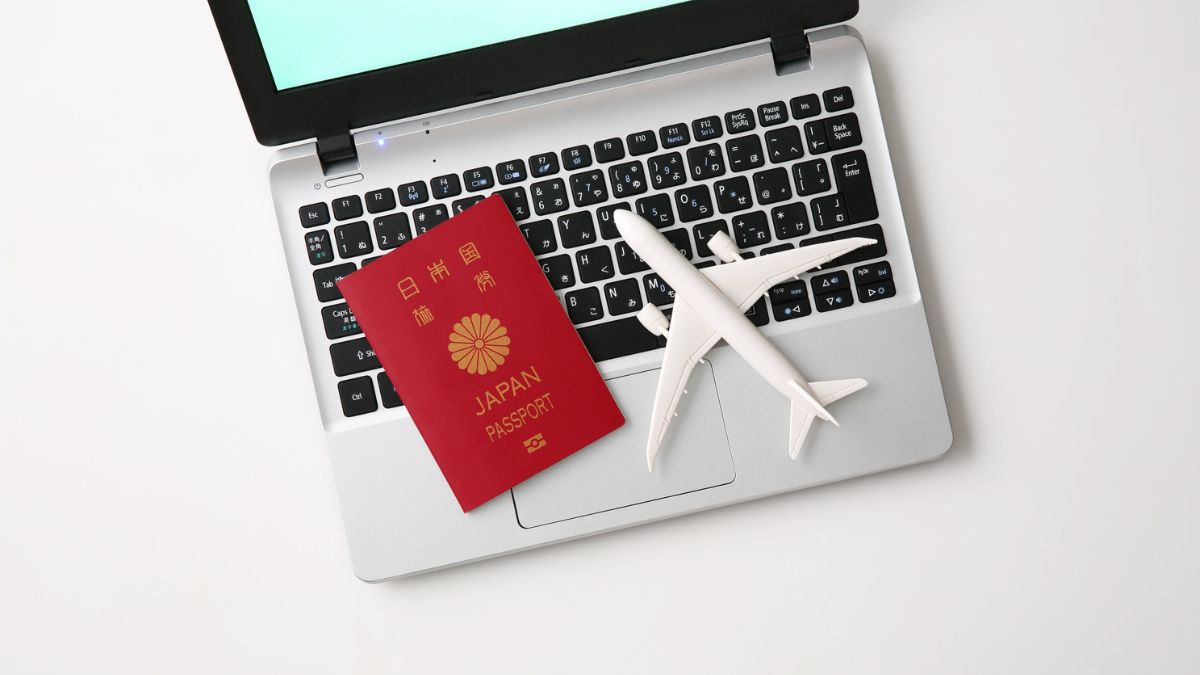 Nowe zasady dla Polaków od 2026 roku Foto: laptop, paszport i mały plastikowy samolot