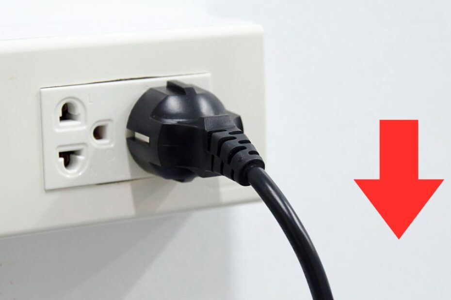 Nowe taryfy prądu i gazu 2026 Foto: wtyczka w kontakcie, czerwona strzałka w dół