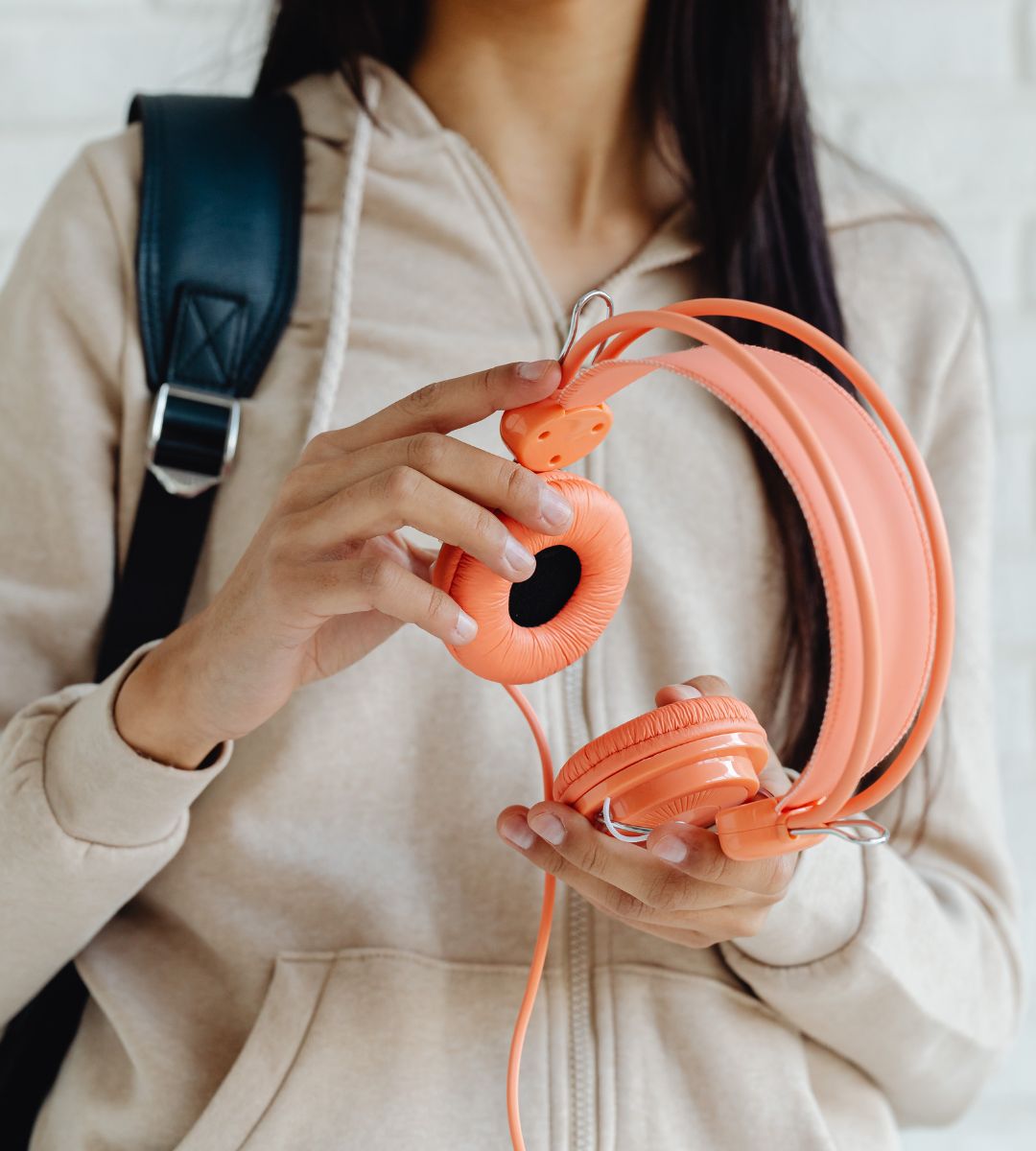 Przewodowe słuchawki znów podbijają świat Foto: kobieta trzyma słuchawki przewodowe