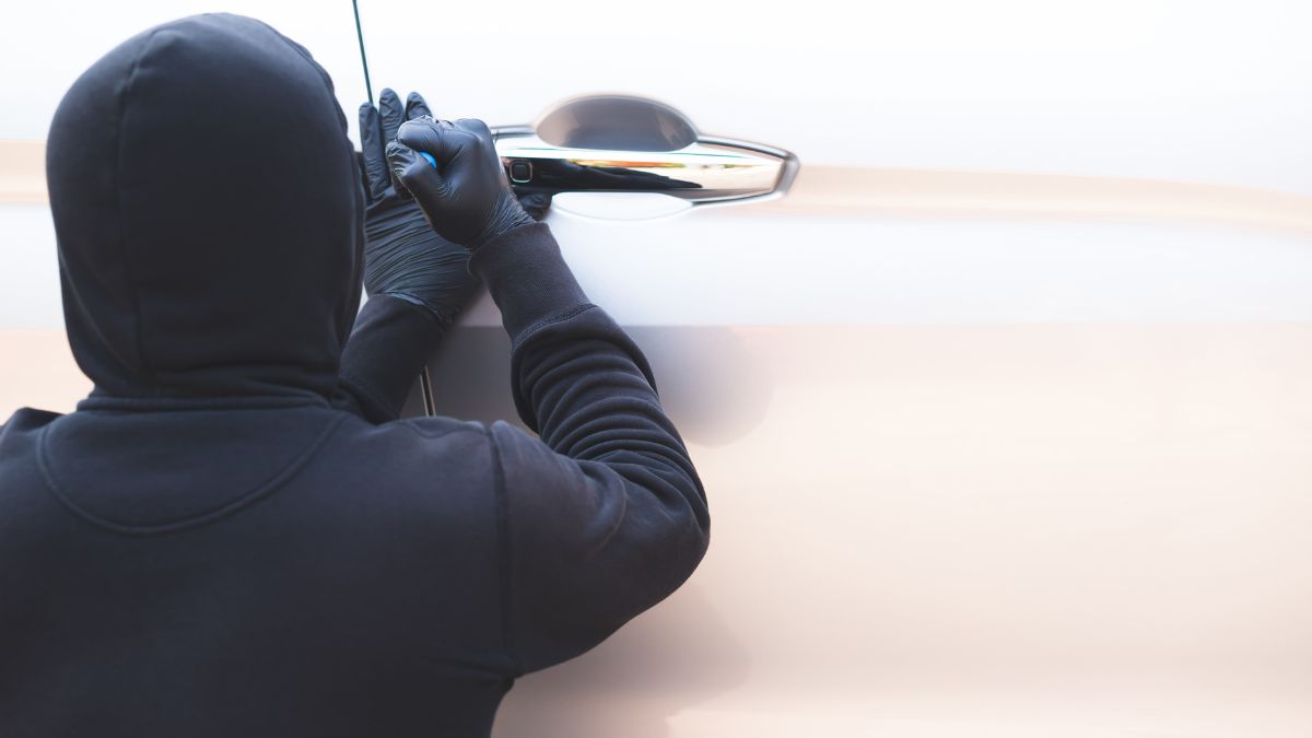 miasta i dzielnice w UK z najwyższą przestępczością Foto: zamaskowany złodziej próbuje włamać się do samochodu