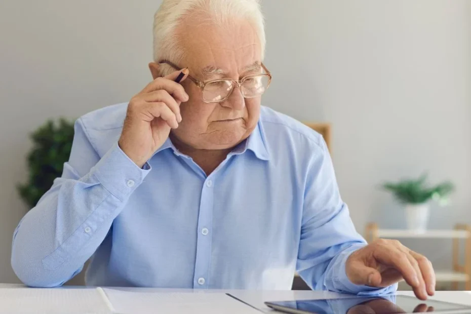 Opodatkowanie oszczędności emerytalnych w UK Foto: emeryt sprawdzający informację na tablecie