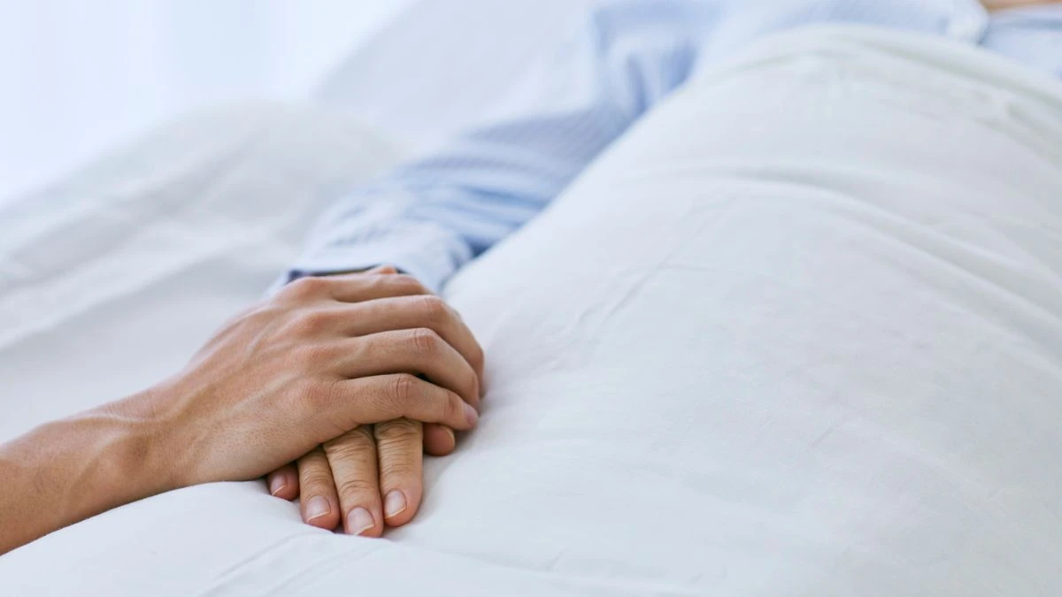 Zmiana osobowości okazała się objawem śmiertelnej choroby Foto: osoba trzymająca dłoń chorego