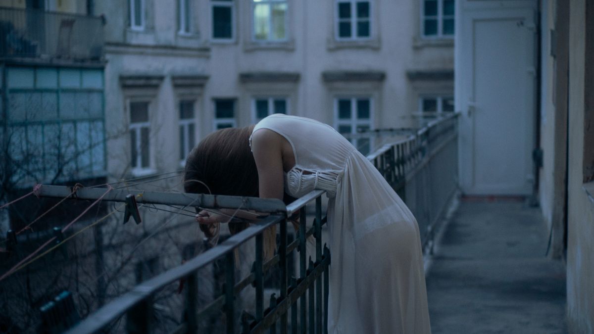 Tragiczna śmierć studentki po diecie wegańskiej Foto: kobieta wychylające się przez balkon