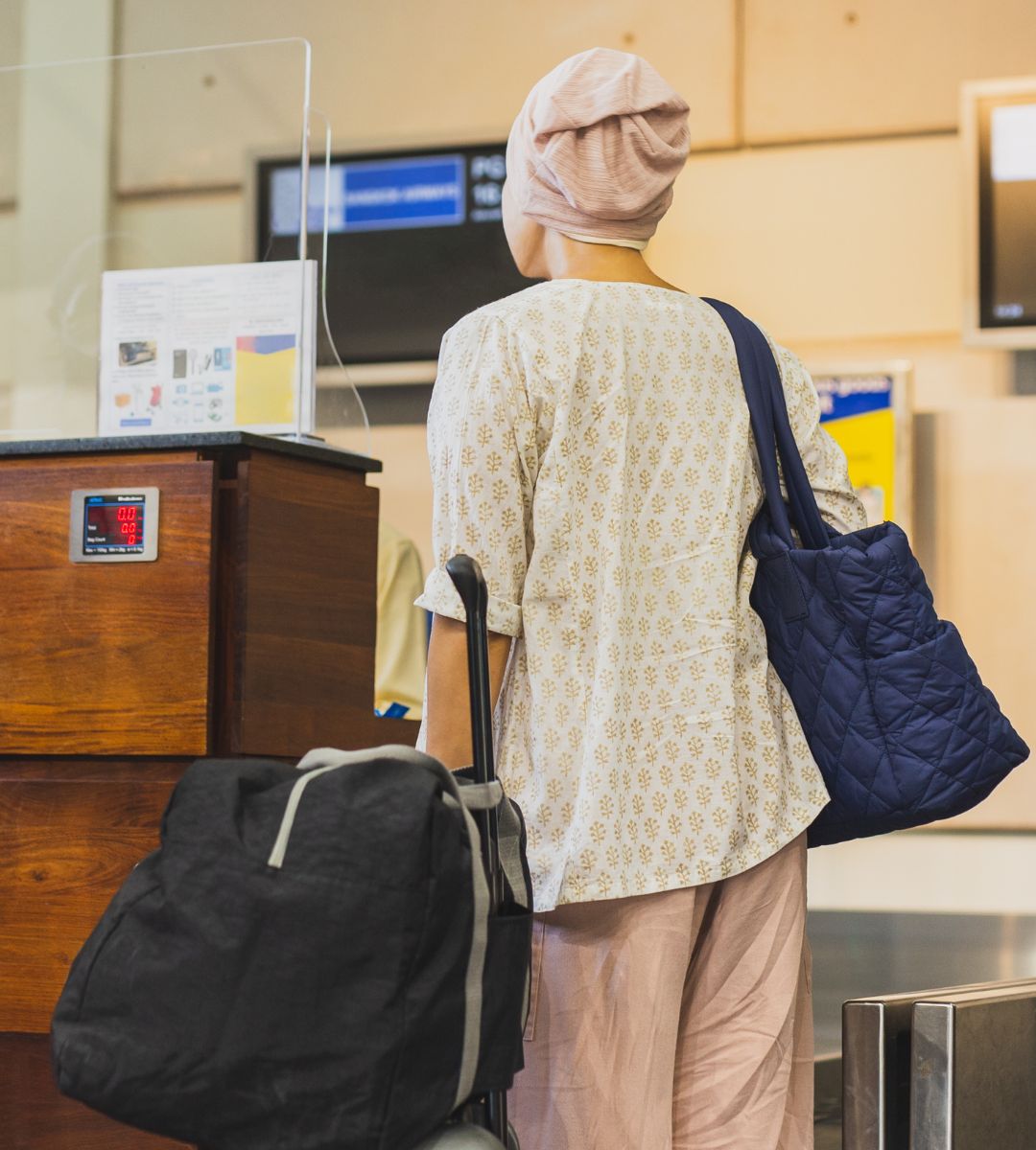 na czym polega bag pooling Foto: kobieta przy stanowisku check-in na lotnisku