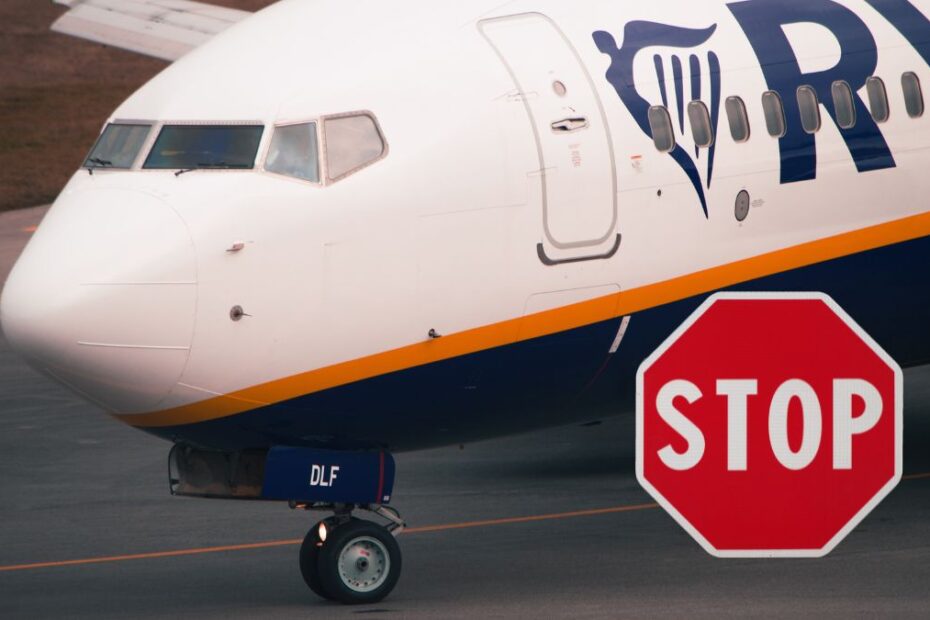Ryanair tnie siatkę połączeń przed wakacjami Foto: samolot linii Ryanair i znak stop