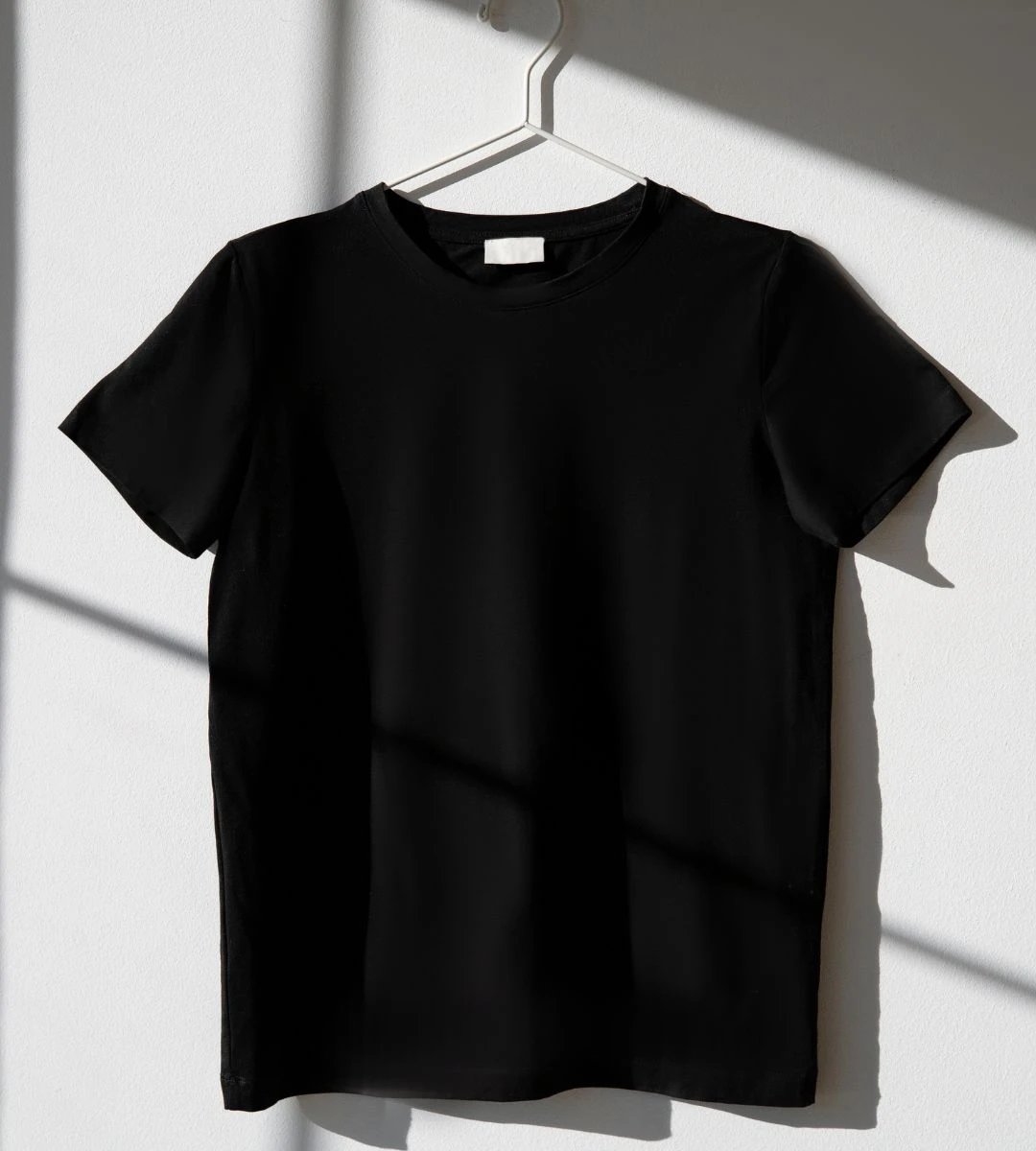 Jaka jest uczciwa cena za dobry T-shirt? Foto: czarna koszulka na wieszaku