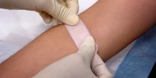 Grupa krwi a długość życia Foto: przyklejenie plasterka n rękę w miejscu pobrania krwi