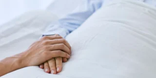 DWP odbiera świadczenia chorym na te trzy schorzenia Foto: osoba trzymająca za rękę chorego