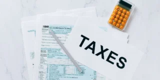 Nowe progi podatkowe w Wielkiej Brytanii Foto: zeznanie podatkowe, kalkulator i napis taxes